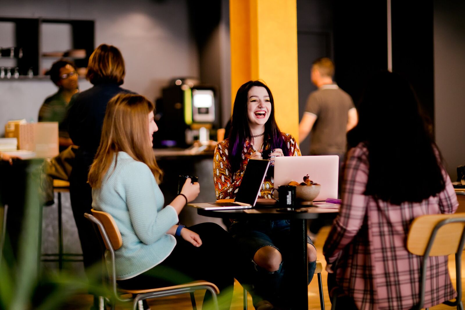 Three women sitting at a table in a cafe or lounge