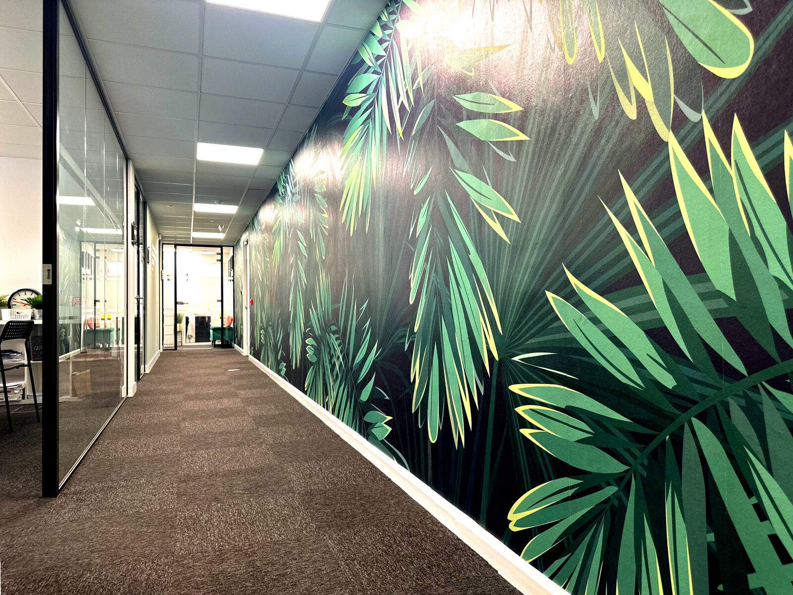Corridor with a large tropical-leaf mural at TBXH