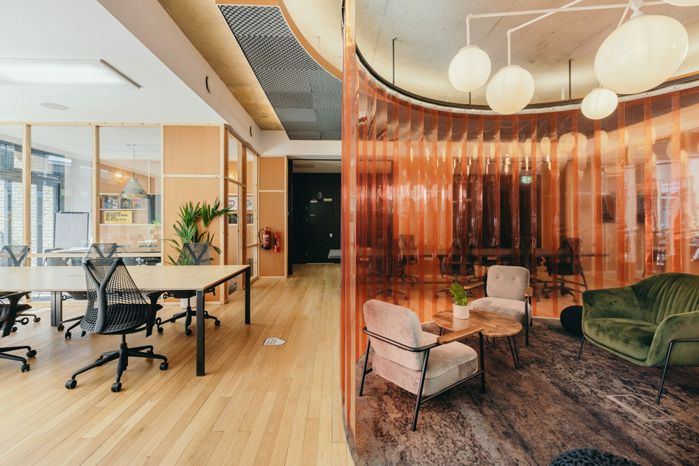 Desks and a lounge corner with armchairs inside The Halley's shared workspace