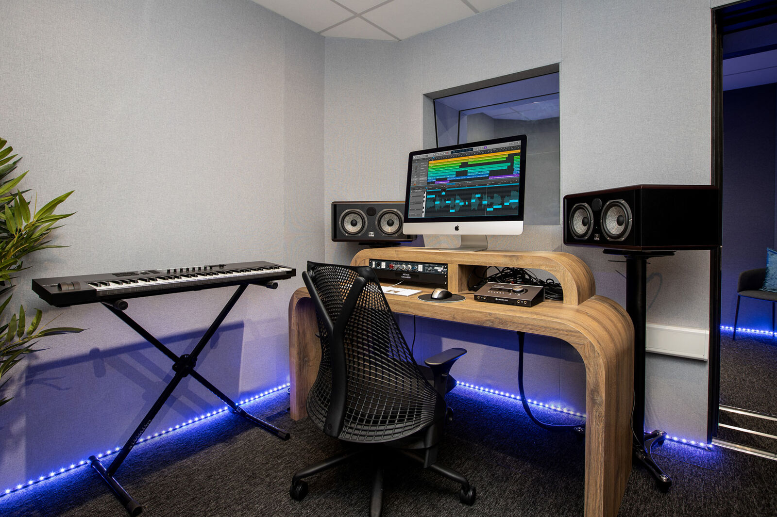Music studio at The Halley with a keyboard, studio monitors and an iMac