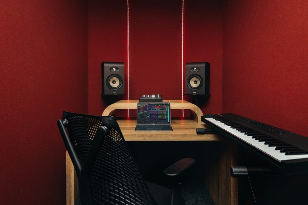 Focus Suite at The Halley with red acoustic walls, keyboard and studio monitors