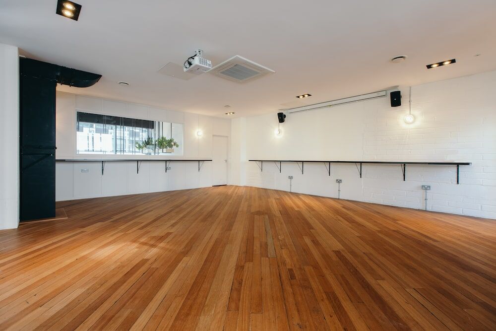 The Gallery event space above The Halley: an empty room with wooden floor and floor-to-ceiling windows